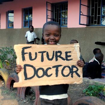 Child with a cardboard reading "Future Doctor"